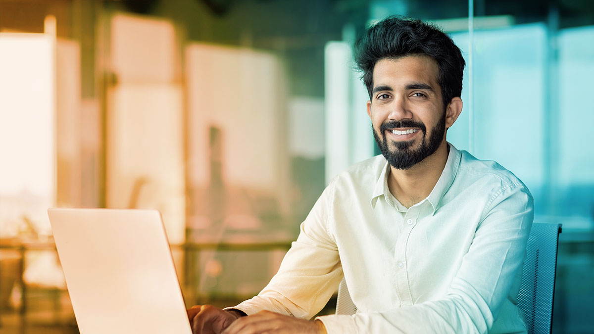 a smiling employee at his computer