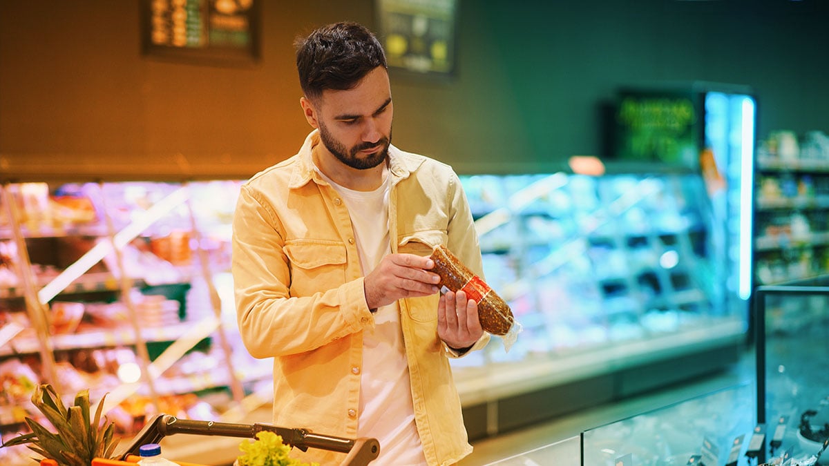 Shopper looking at the expiry date on a meat product.