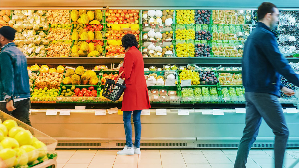 Person grocery shopping in the produce aisle
