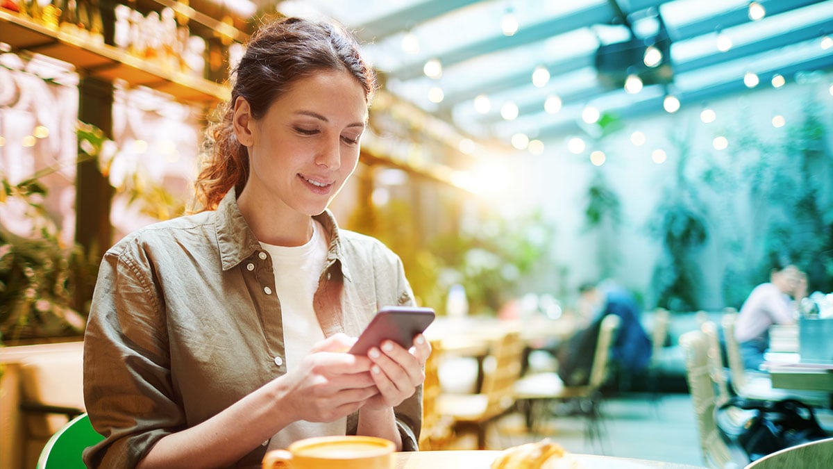 Person making a social post on their phone at a restaurant