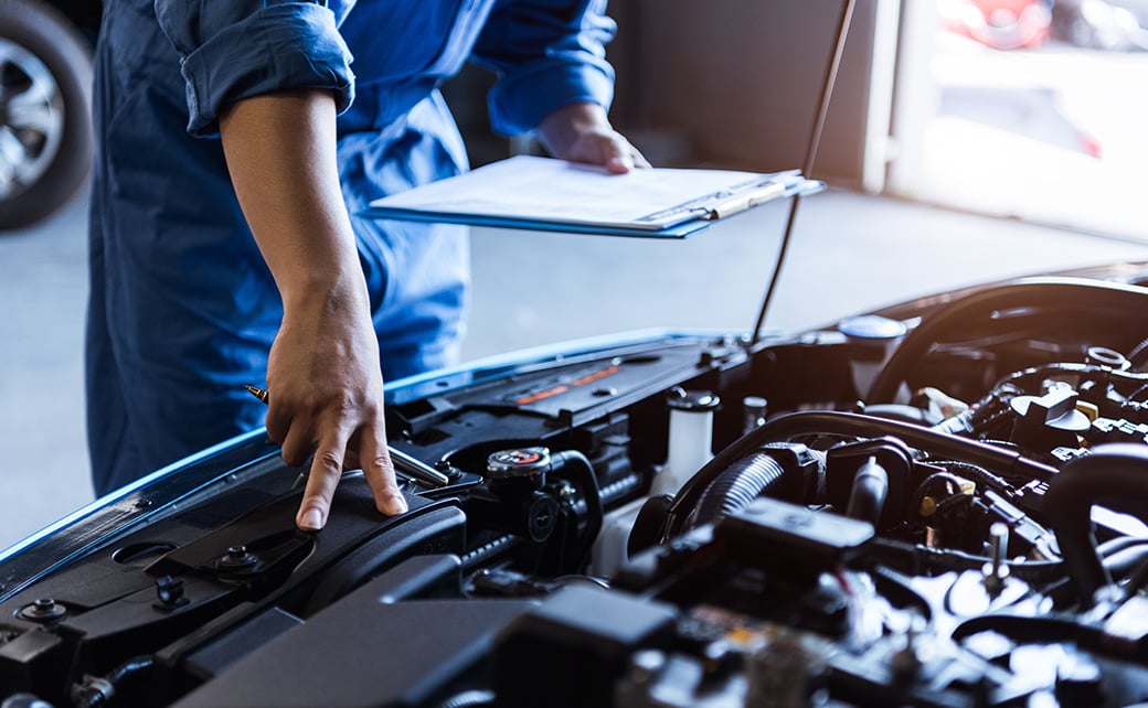 mechanic looking under the hood of a car