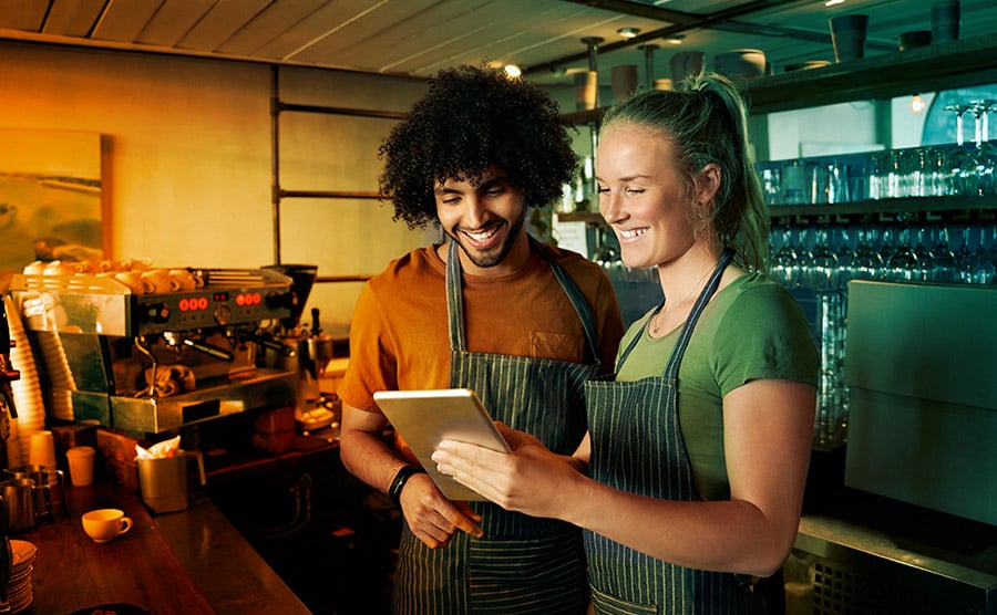 cafe employees looking at tablet together