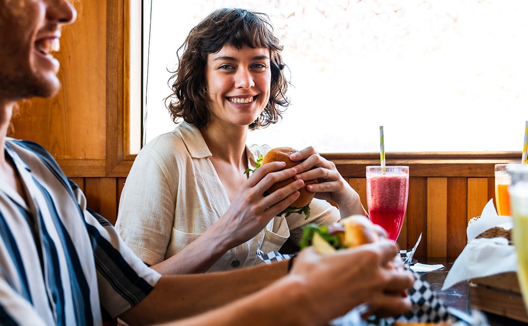 friends enjoying burgers and smoothies at fast casual restaurant